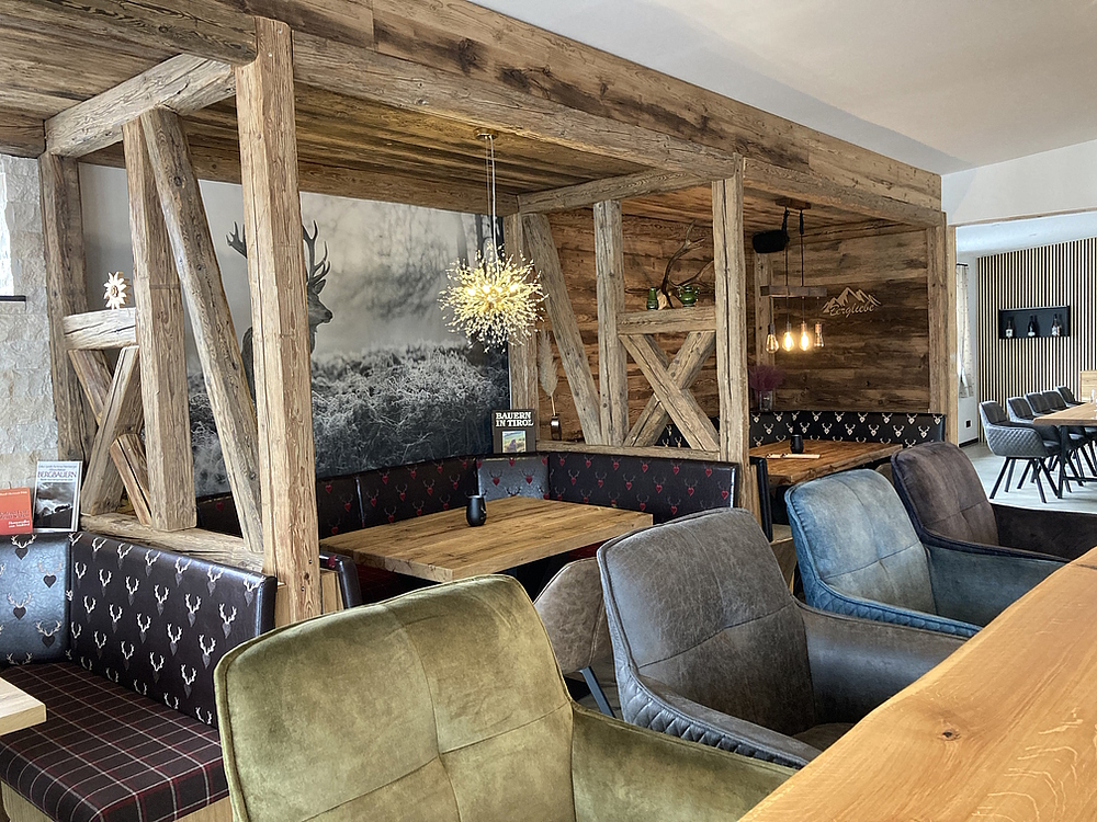 Restaurant Einrichtung für eine Vinothek, bunte Polsterstühle, Massivholztische Eiche, Polstersitzbänke, Altholzfachwerk als Raumteiler