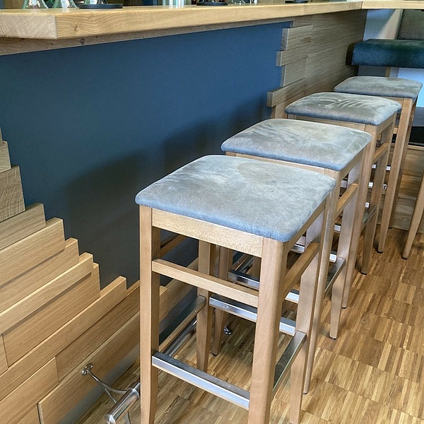 Maßgefertigter Gastraum mit Gastrotheke, Tischen, Stühlen und Bank aus der Schreinerei Hofmann Kreuzwertheim für Natur & City Camping Ellwangen.