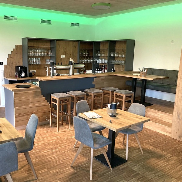 Maßgefertigter Gastraum mit Gastrotheke, Tischen, Stühlen und Bank aus der Schreinerei Hofmann Kreuzwertheim für Natur & City Camping Ellwangen.