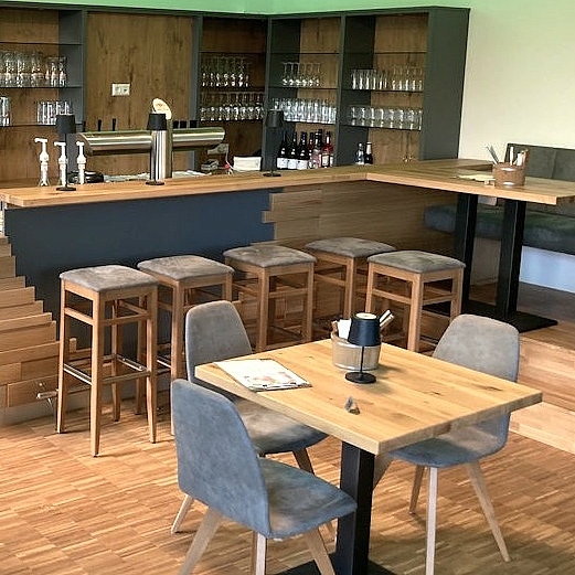 Maßgefertigter Gastraum mit Gastrotheke, Tischen, Stühlen und Bank aus der Schreinerei Hofmann Kreuzwertheim für Natur & City Camping Ellwangen.x