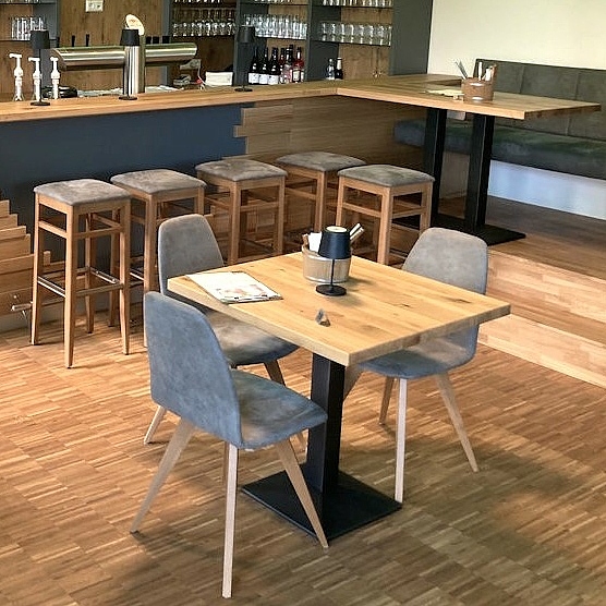 Maßgefertigter Gastraum mit Gastrotheke, Tischen, Stühlen und Bank aus der Schreinerei Hofmann Kreuzwertheim für Natur & City Camping Ellwangen.